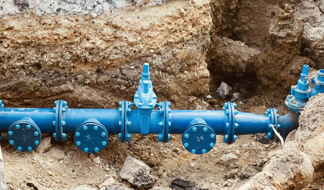A new blue water main with valves in an open trench